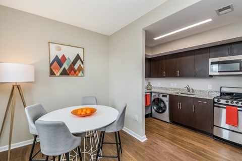 A modern kitchen with a dining table and chairs.