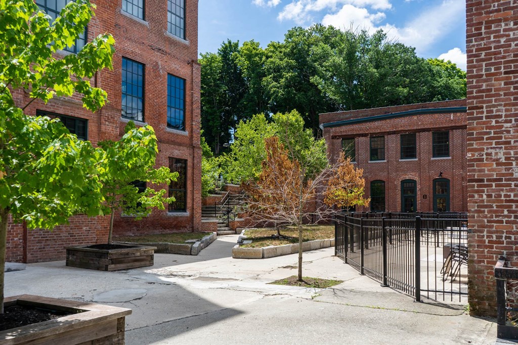 the courtyard of a building with trees and brick buildings
