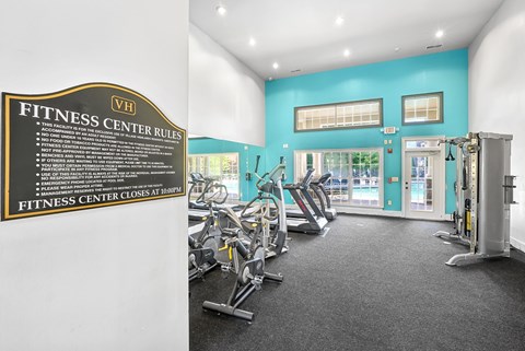A fitness center with a sign that lists the rules.