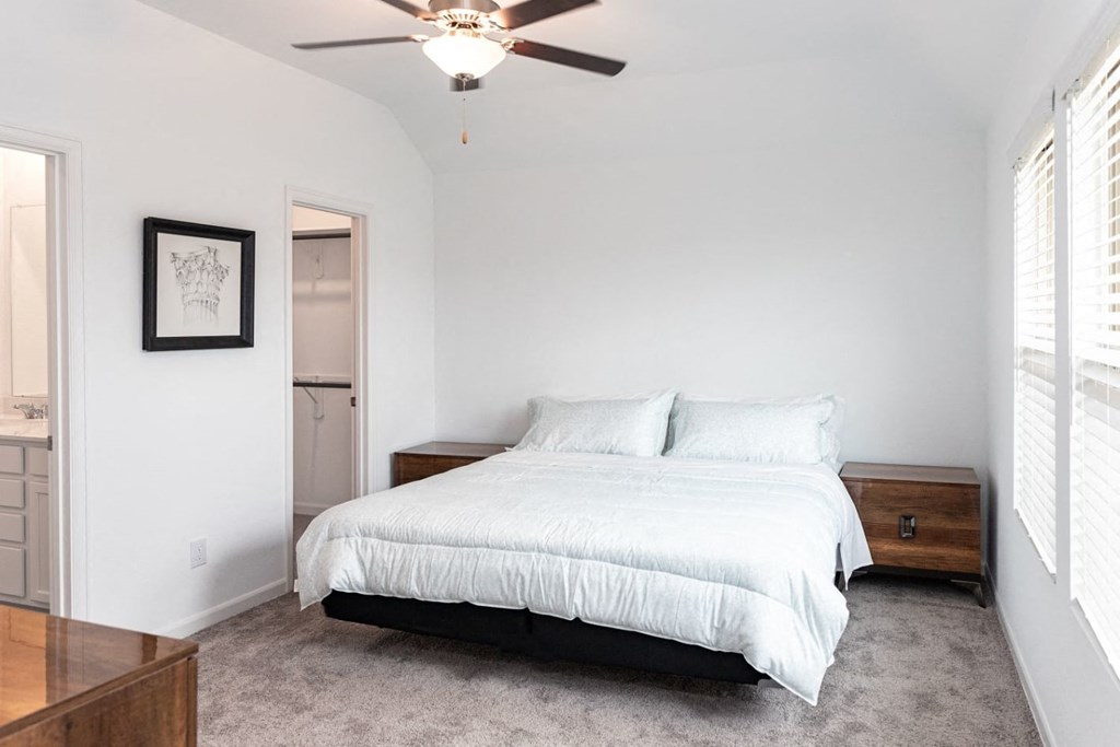 Three-Bedroom Homes for Rent in Humble, TX - Edgewater at the Lagoon - Bedroom with Plush Carpeting, a Large Window, a Ceiling Fan, a Closet, and a Bathroom