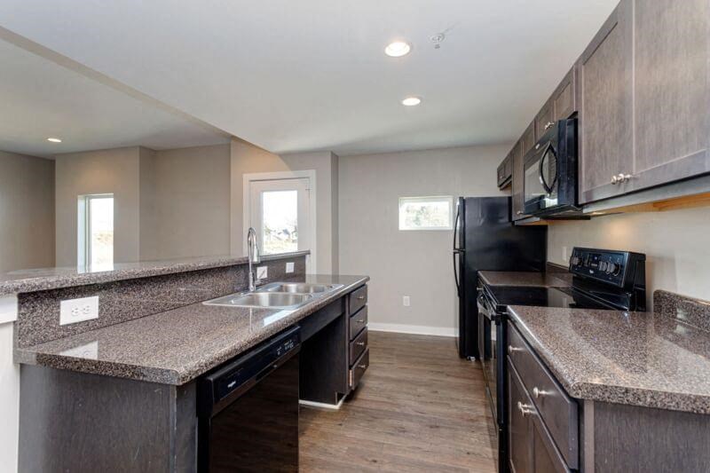 a kitchen with granite counter tops and black appliances