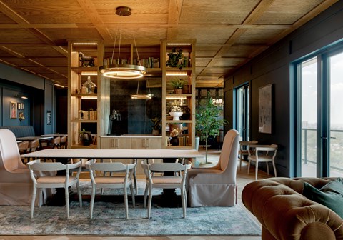 A modern dining room with a large table and chairs.