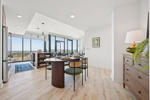 A modern dining room with a wooden table and chairs.