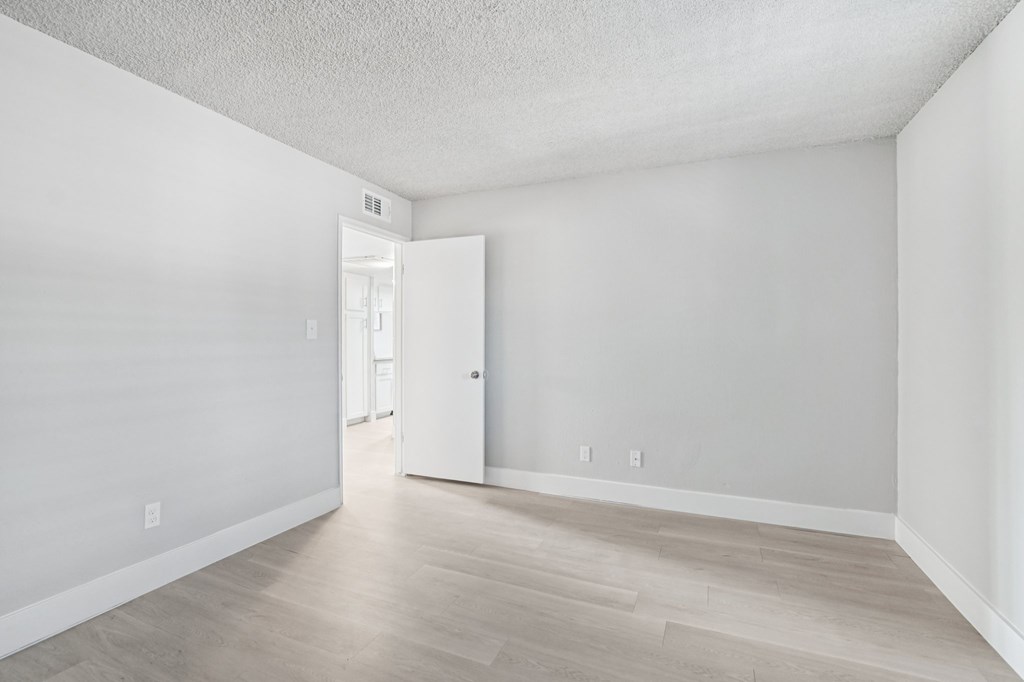 A white room with a doorway leading to another room.