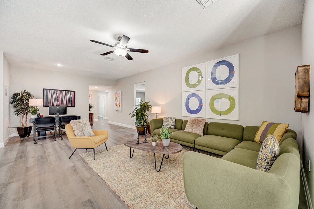 Open-concept house with hardwood floors and tall ceilings at The Groves at Lake Ella in Lady Lake, Florida, a pet-friendly rental community.