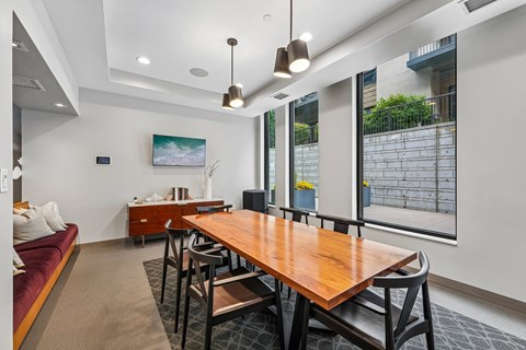 A modern dining room with a wooden table and chairs.