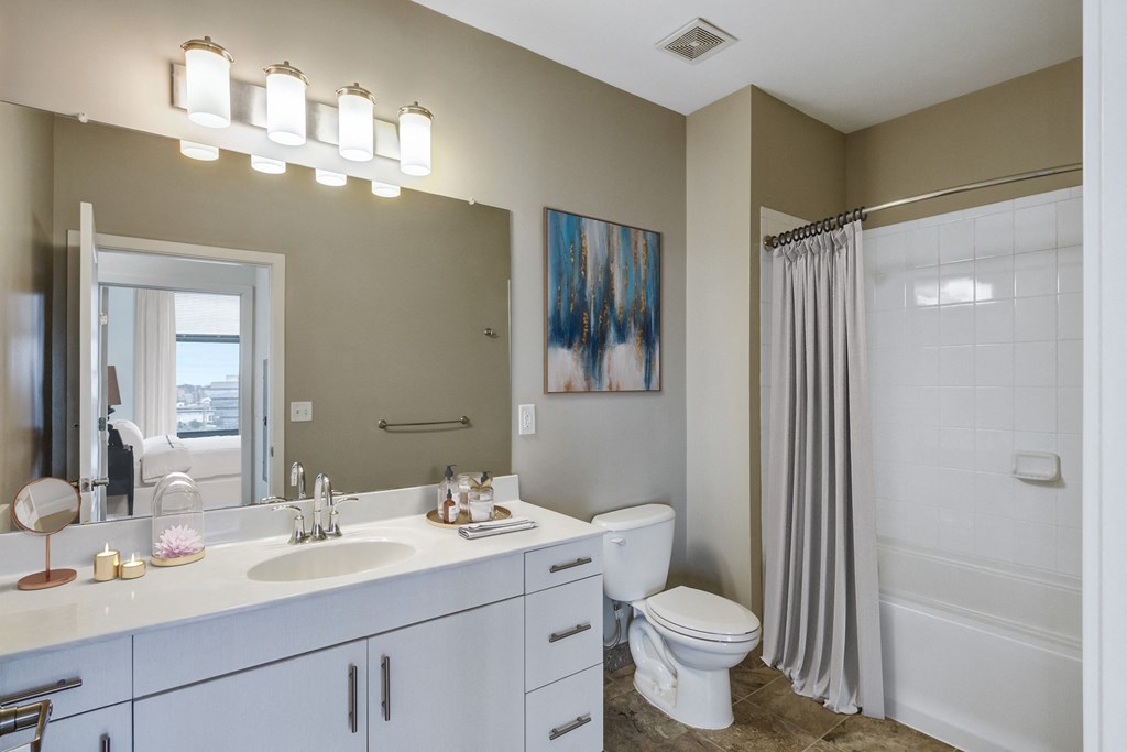 bathroom with white vanity and tub shower