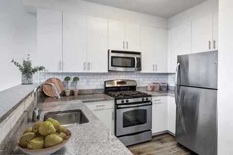 a kitchen with white cabinets and stainless steel appliances