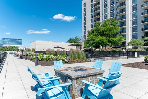 A patio with blue chairs and a table.