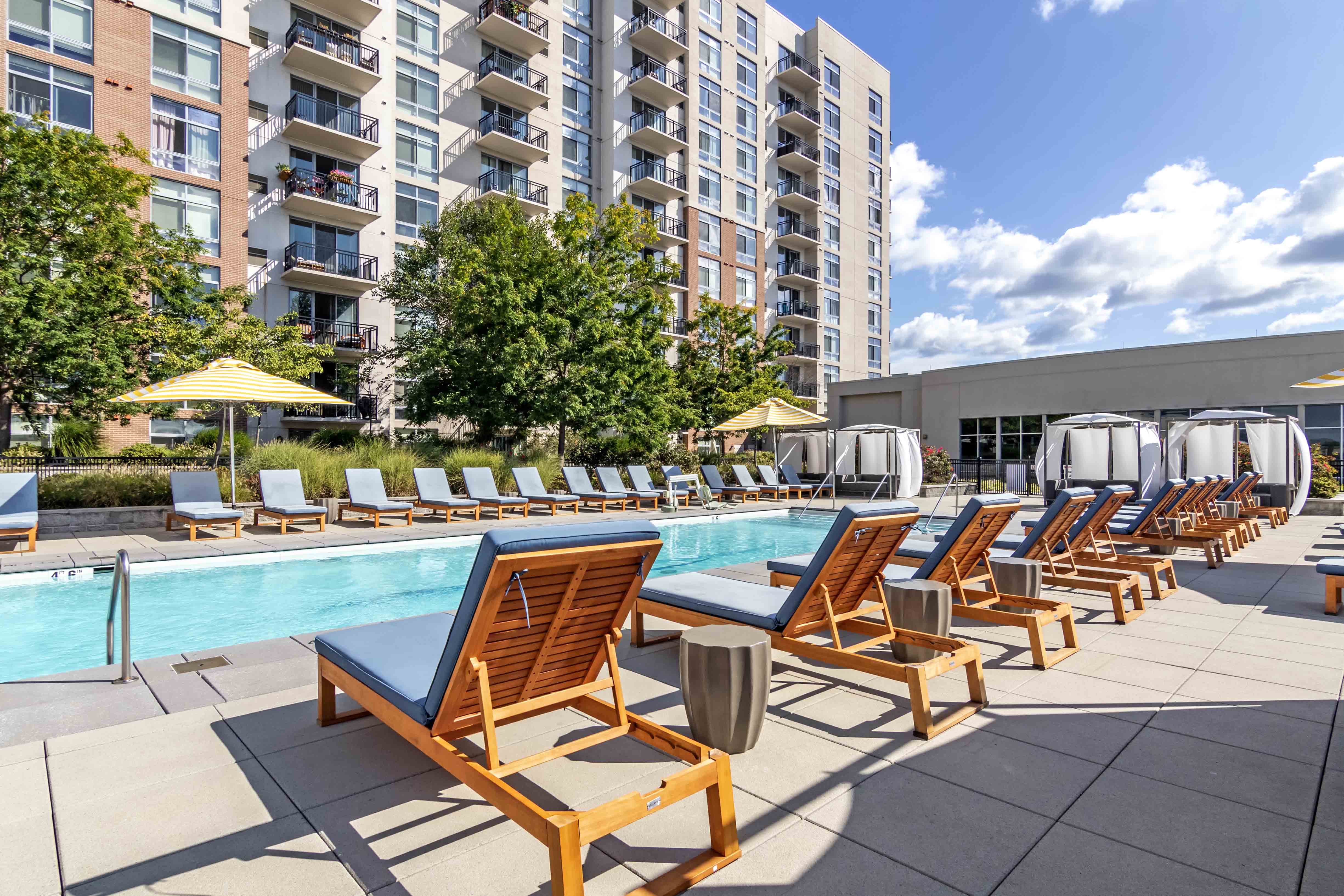 Pool sun deck with teak lounge chairs and cabanas