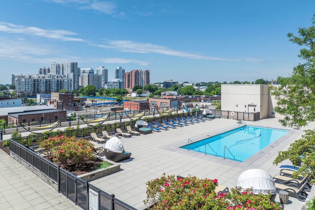 a swimming pool at a hotel with a city in the background