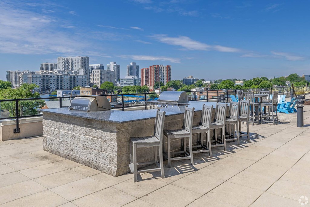 a bar with chairs and tables on a rooftop overlooking the city