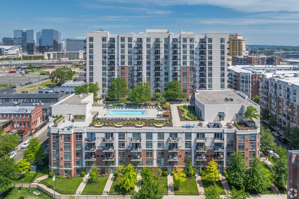 an aerial view of a building with a pool in the middle