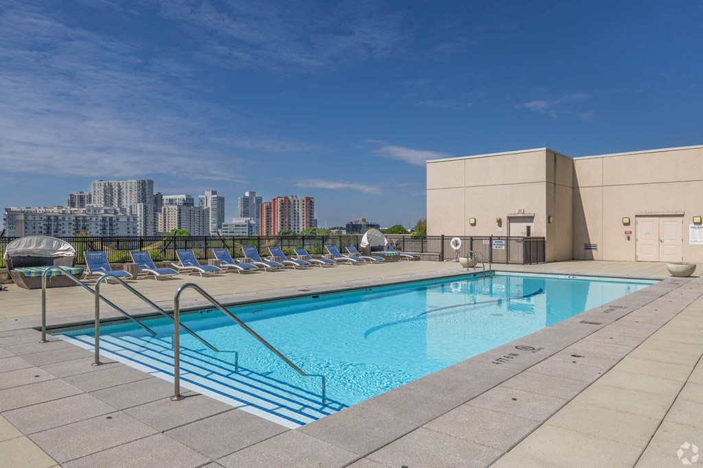 a pool on the roof of a building with a city in the background