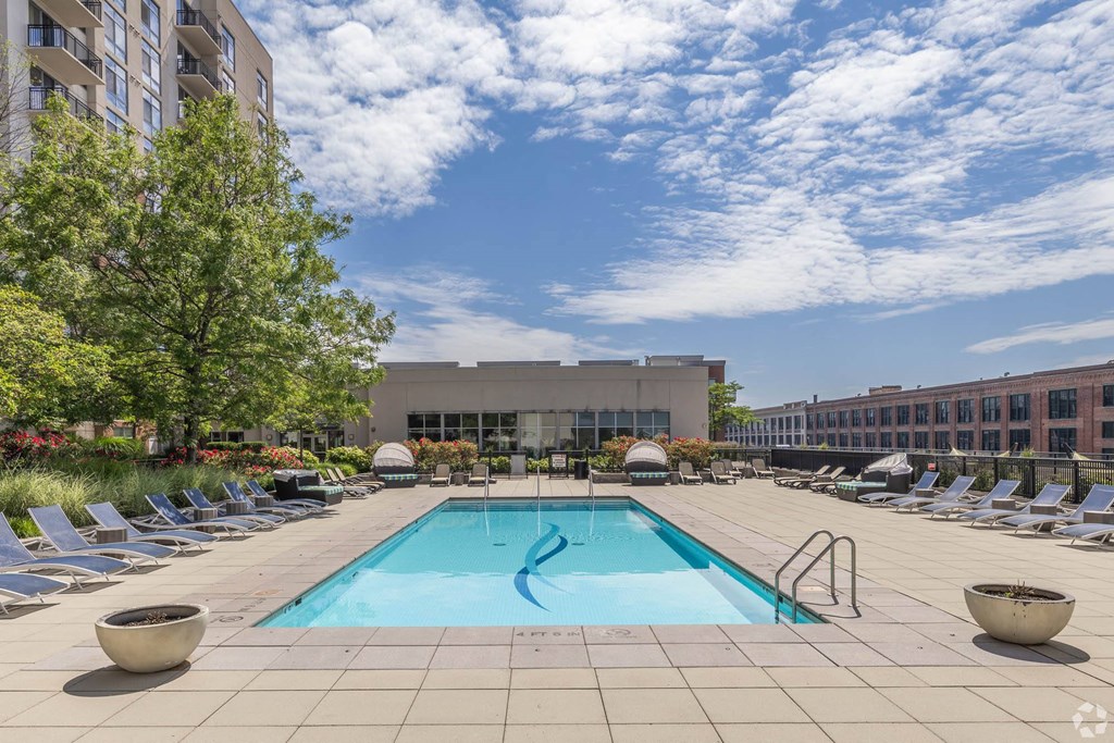 a swimming pool at a hotel with chairs around it