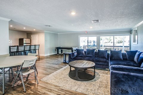 a living room with blue couches and a table and chairs