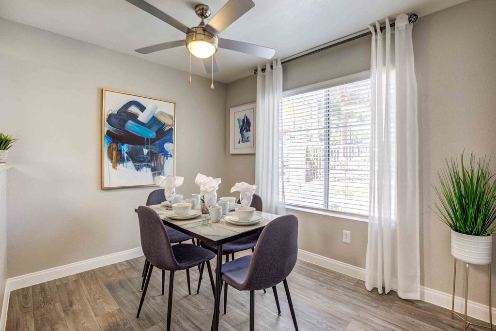 a dining room table with chairs and a ceiling fan