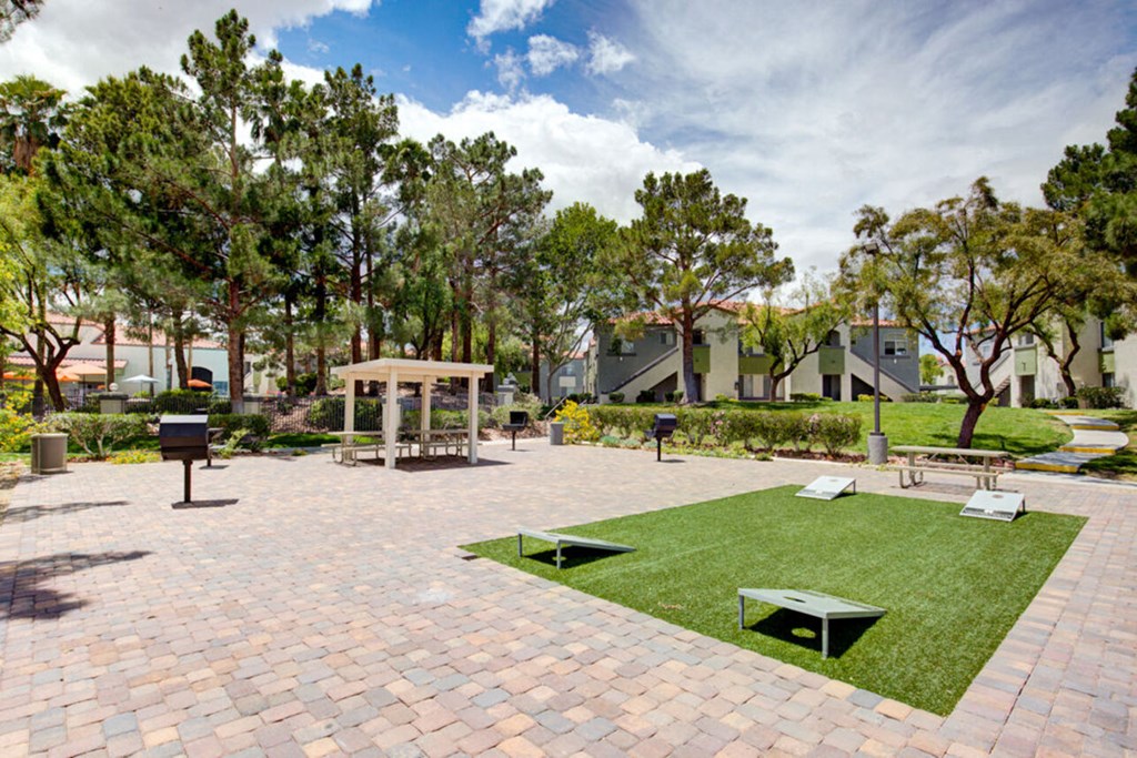 a park with grass and picnic tables and trees