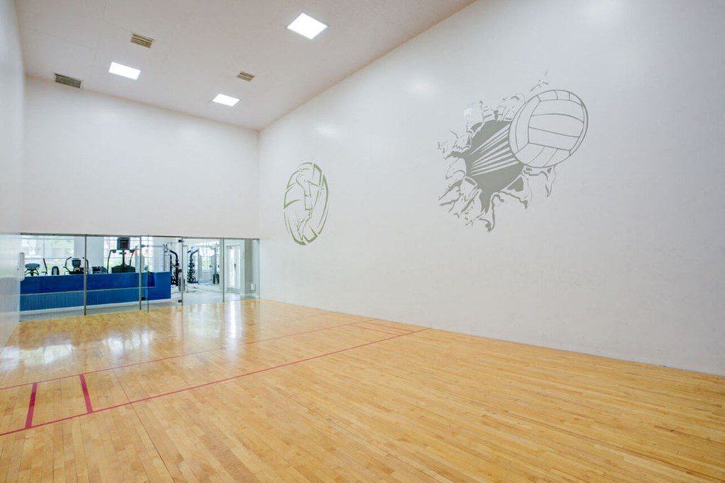 a large room with a basketball court and paintings on the wall