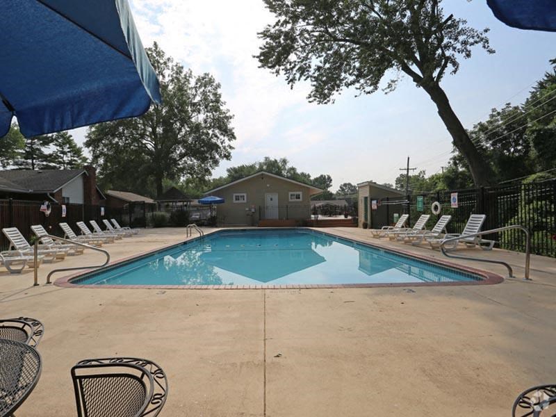 a swimming pool with chairs and umbrellas around it
