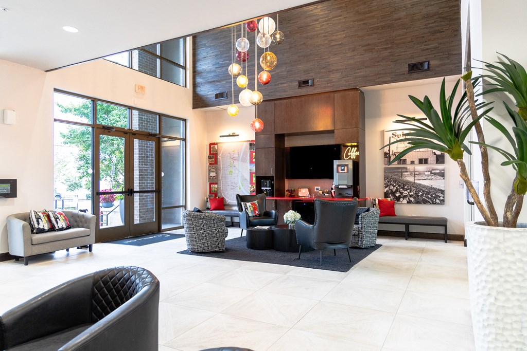 Modern lobby with seating area, coffee station, and decorative lighting.