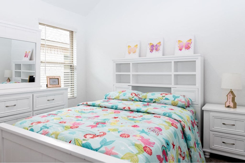 a bedroom with a bed and two white dressers
