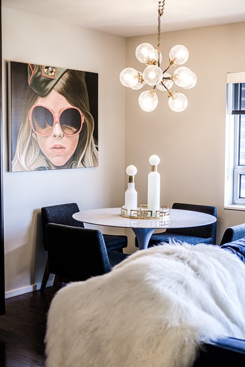 a bedroom with a bed and a table and a picture of a woman wearing sunglasses