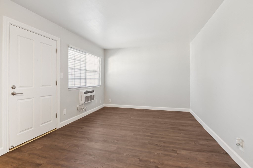 A room with a white door and a window with blinds.