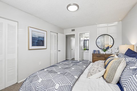 A bedroom with a large bed and a picture on the wall.