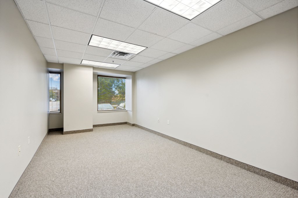 an empty room with white walls and a window