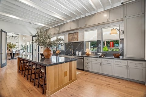 A kitchen with a long island and wooden floors.