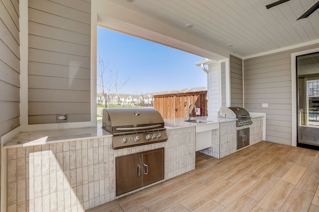 a large outdoor kitchen with a grill and a window
