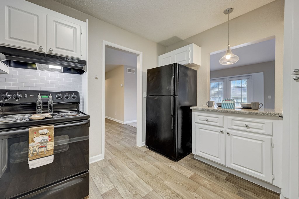 Apartments In Sandy Springs, GA for Rent – Celebration at Sandy Springs - an open kitchen with black appliances and white cabinets