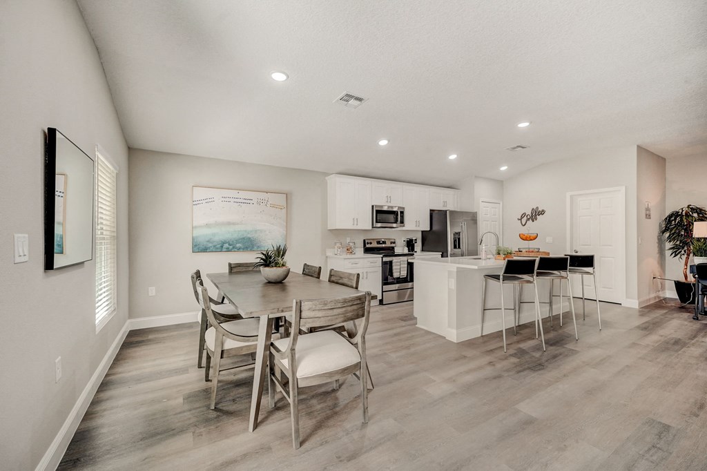 Dining room and kitchen with a table and chairs at The Groves at Lake Ella in Lady Lake, Florida, a pet-friendly rental community.