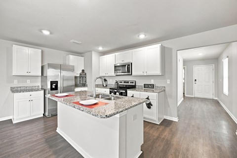 A kitchen with white cabinets and a granite countertop.