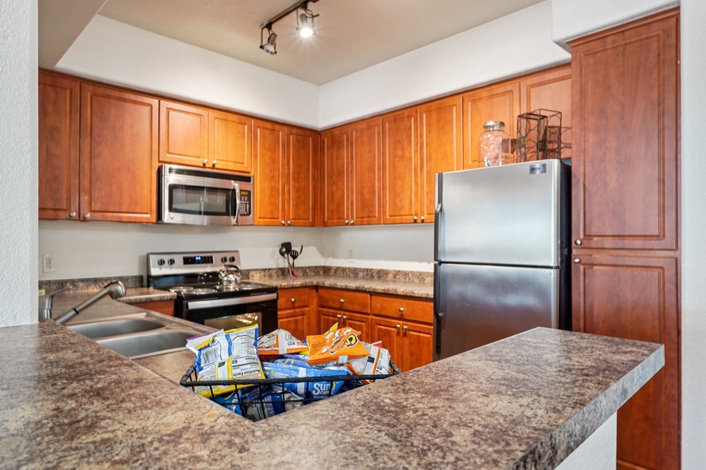 A kitchen with wooden cabinets and a granite countertop.
