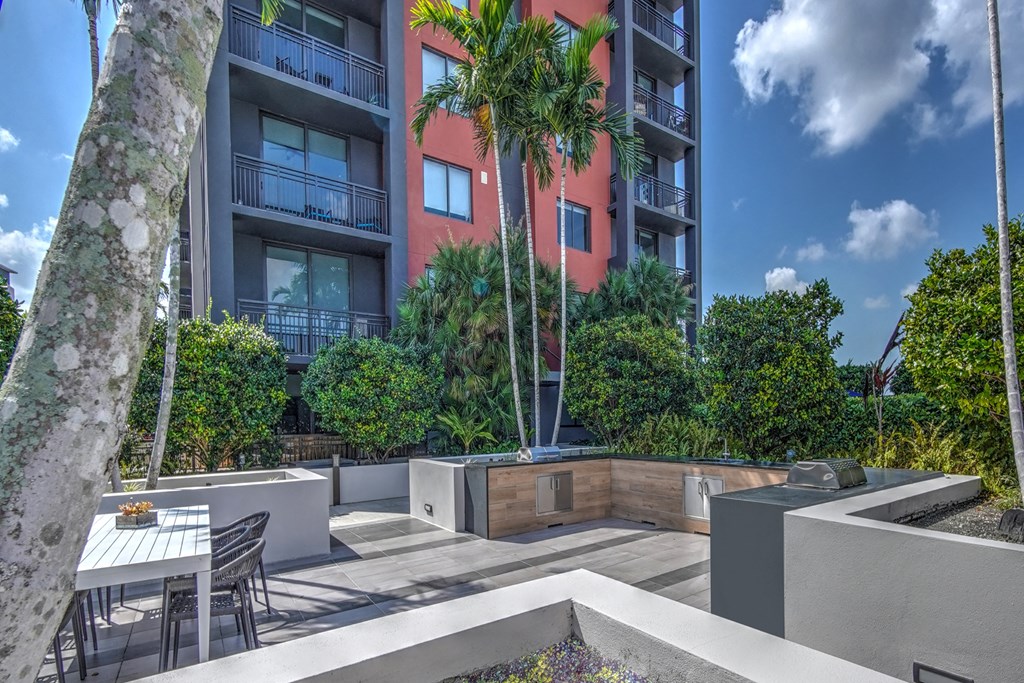 a patio with a table and chairs in front of an apartment building