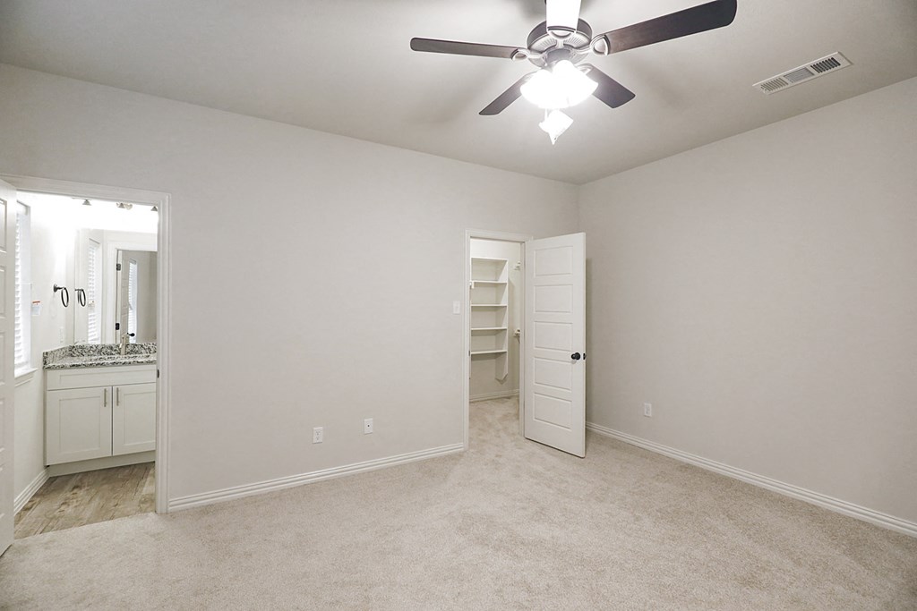 a bedroom with a ceiling fan and a closet
