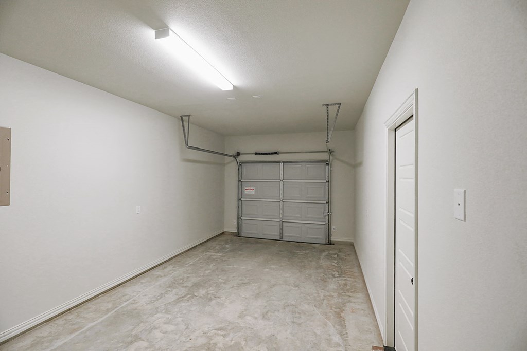 an empty room with a garage door and a door to a closet