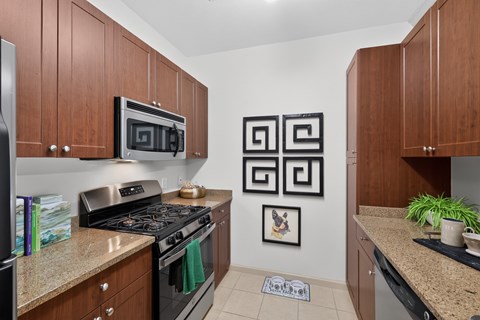 A kitchen with brown cabinets and a black stove top oven.