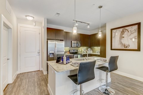 A kitchen with a bar area and a painting on the wall.