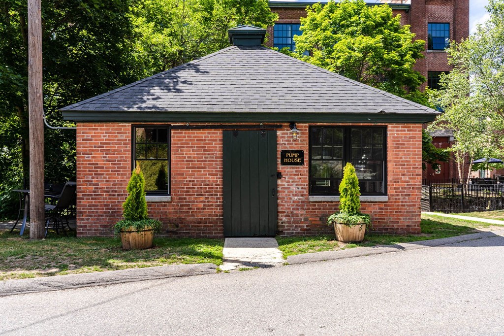 a small red brick building with a green door