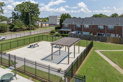 A black fence surrounds a playground with a wooden structure.