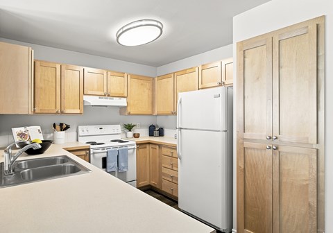 A kitchen with wooden cabinets and a white refrigerator.