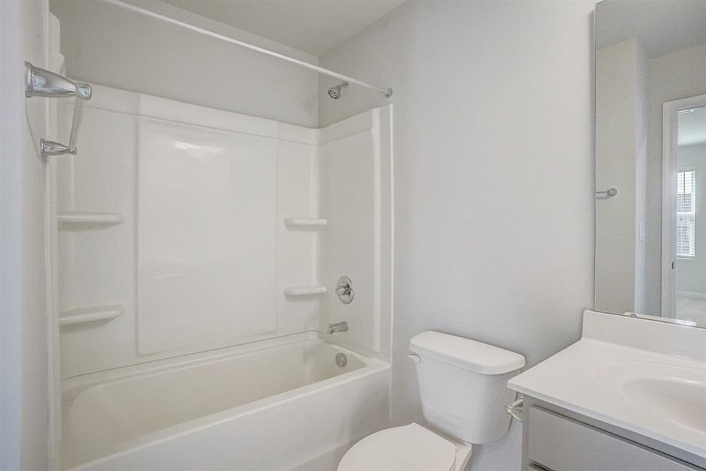 A white bathroom with a toilet, sink, and bathtub.