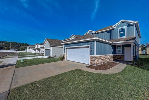 Row of newly constructed single-family homes with attached garages.