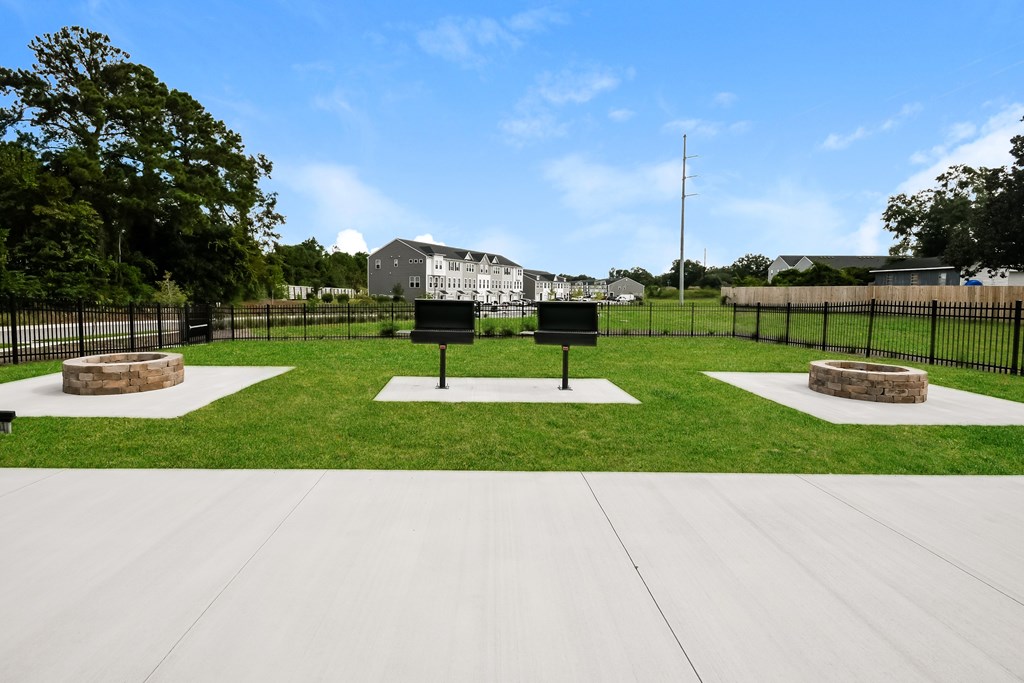 A park with a white sign and a black fence.