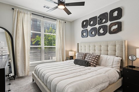 A bedroom with a large bed and a ceiling fan.