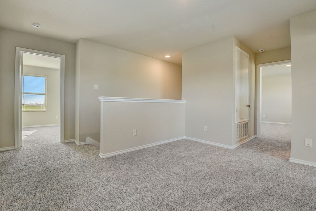 an empty living room with white walls and carpet