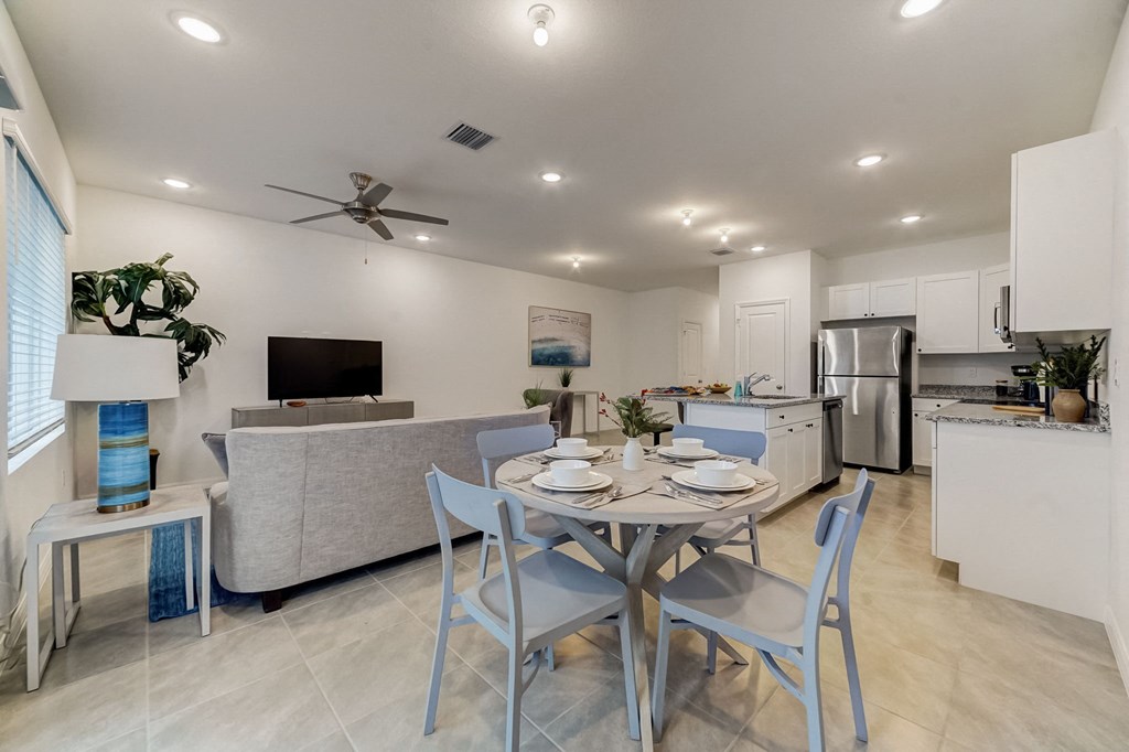 Boatman Hammock Townhomes in Lake Worth, FL photo of  a dining area with a table and chairs and a living room with a kitchen